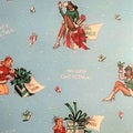 Christmas scene with model girls holding presents background blue colours, girls in green, and red suits - Whispers of the Valley Fabric
